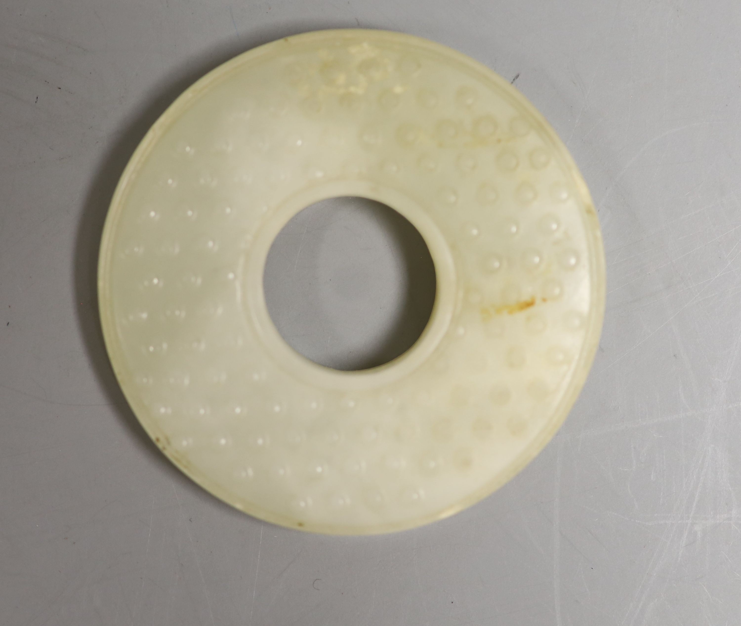 A Chinese pale celadon jade bi disc, 6cm diameter